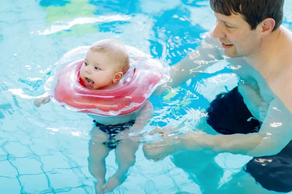 スイミング プールでかわいいかわいい赤ちゃんと一緒に泳ぐ幸せな中年の父親. — ストック写真