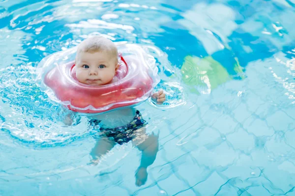 Słodkie małe dziecko nauki pływania z pierścieniem kąpieli w krytym basenem — Zdjęcie stockowe