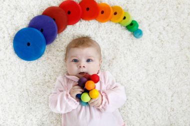 Renkli ahşap çıngırak oyuncakla oynamak sevimli bebeğim
