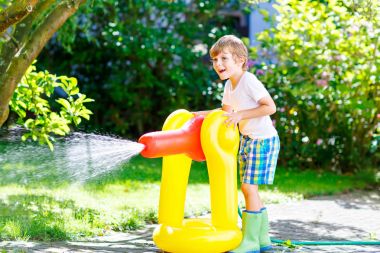 bir bahçe hortumu su yağmurlama ile oynarken küçük çocuk çocuk