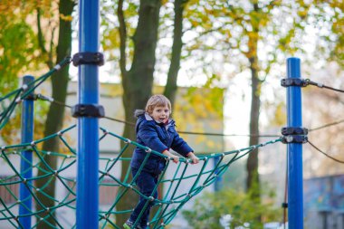 Açık sahada sonbahar gününde tırmanma çocuk evlat