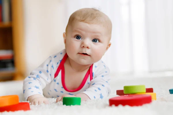 Bonito bebê menina brincando com colorido brinquedo chocalho de madeira — Fotografia de Stock