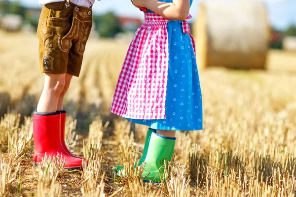 Két gyerek hagyományos bajor jelmezben, piros és zöld masszázsban. — Stock Fotó