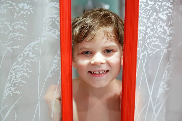 Felice ragazzino nella cabina doccia bagnato e sorridente . — Foto Stock