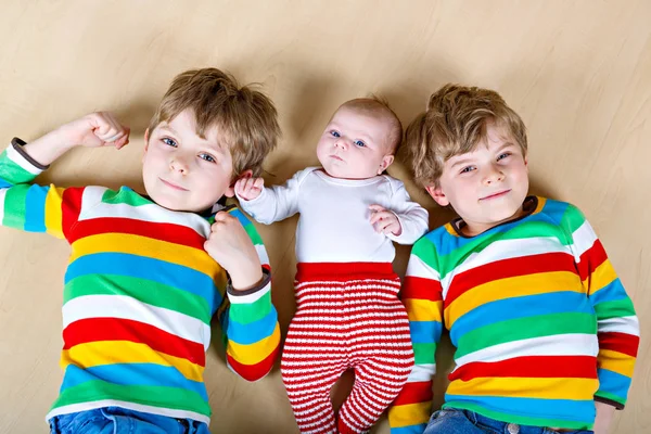 Two happy little preschool kids boys with newborn baby girl — Stock Photo, Image