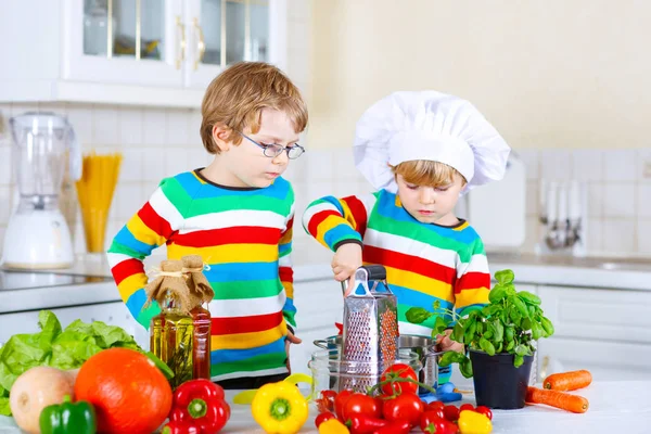 Два маленьких мальчика делают салат из овощей — стоковое фото