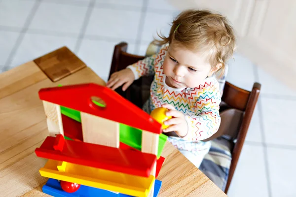 Очаровательная милая красивая маленькая девочка, играющая с образовательными игрушками дома или в детской . — стоковое фото