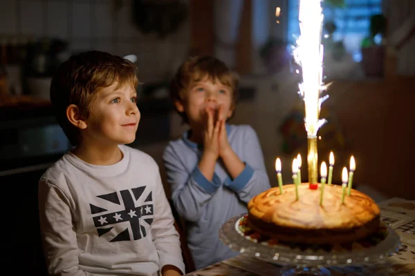 Dos niños hermosos, niños preescolares celebrando cumpleaños y soplando velas —  Fotos de Stock