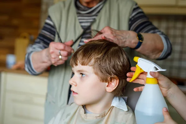 Hermoso niño con cabellos rubios consiguiendo su primer corte de pelo . — Foto de Stock