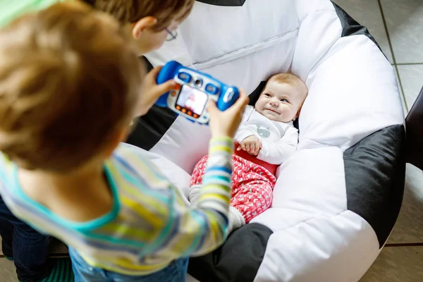 Dois irmãos crianças meninos tirando foto com câmera de brinquedo de bebê bonito menina . — Fotografia de Stock