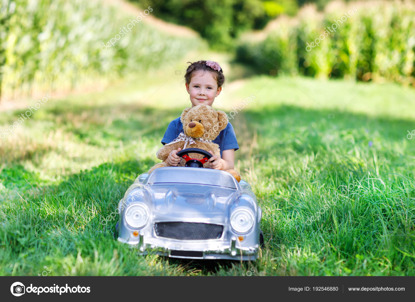 Petite fille d'âge préscolaire conduisant une grosse voiture jouet et  s'amusant à jouer avec un gros ours en peluche image libre de droit par  romrodinka © #192546880