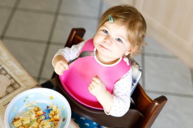 Kaşık püresi ve sebze püresinden yiyen sevimli bir kız bebek. yemek, çocuk, beslenme ve insanlar konsepti