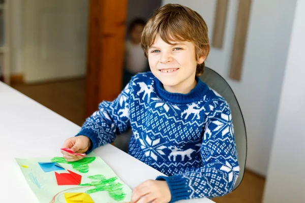 Kleine jongen maken papier origami tulp bloemen voor een ansichtkaart voor moeders dag of verjaardag. Schattig kind van de lagere school die handwerk doet — Stockfoto