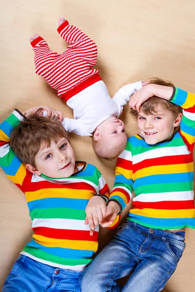 Twee gelukkige preschool kinderen jongetjes met pasgeboren babymeisje — Stockfoto