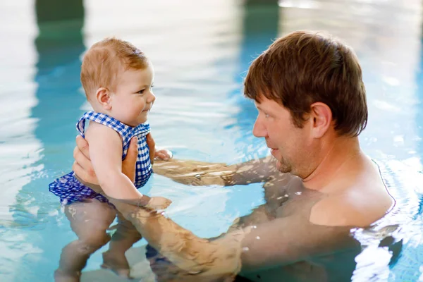 Счастливый отец среднего возраста плавает с милой очаровательной малышкой в бассейне. — стоковое фото
