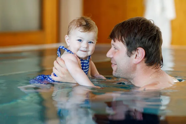 Feliz padre de mediana edad nadando con linda niña adorable en la piscina. —  Fotos de Stock