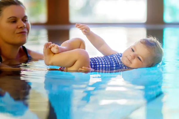 Mãe feliz nadando com bonito adorável bebê menina filha na piscina passar férias spa — Fotografia de Stock