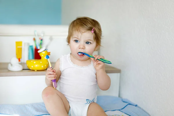 小さな赤ちゃんの女の子は歯ブラシを保持し、最初の歯をブラッシング.幼児学習へクリーンなミルク歯. — ストック写真
