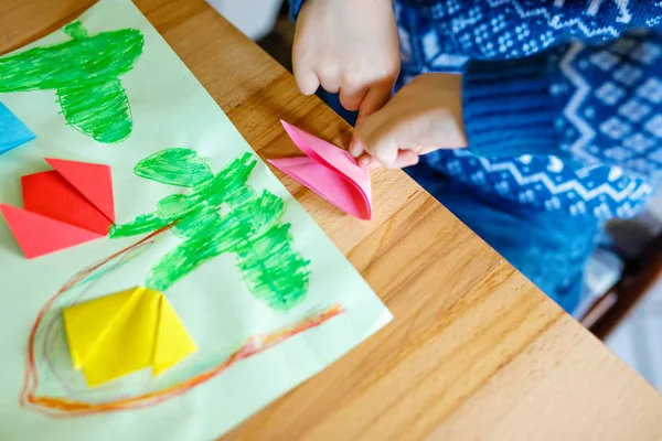 Primer plano de las manos de un niño pequeño haciendo flores de tulipán origami para una postal para el día o cumpleaños de las madres. — Foto de Stock