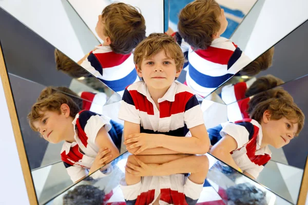 Petit garçon s'amuser avec des expériences avec des miroirs dans un musem. Portrait d'un écolier heureux et souriant . — Photo