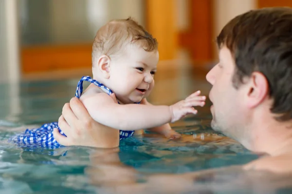 Gelukkig middelbare leeftijd vader zwemmen met schattige baby meisje in het zwembad. — Stockfoto