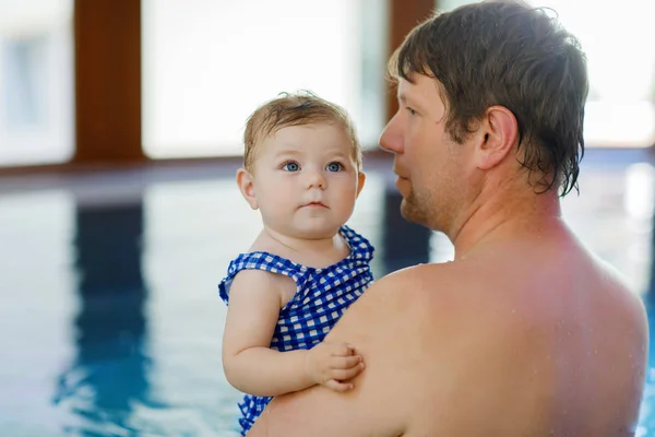 Gelukkig middelbare leeftijd vader zwemmen met schattige baby meisje in het zwembad. — Stockfoto