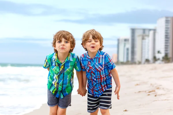 Due ragazzini che corrono sulla spiaggia dell'oceano — Foto Stock