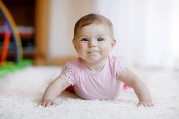 Portret van een meisje in een witte, zonnige slaapkamer. Pasgeboren kind leren kruipen. — Stockfoto