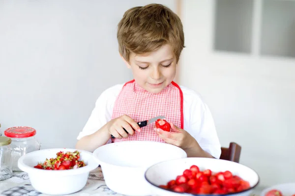 Little blond kid boy helping and making strawberry jam in summer — Stock Photo, Image