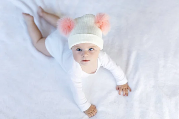 Niedliche entzückende Baby-Kind mit warmen weißen und rosa Hut mit niedlichen Noppen — Stockfoto