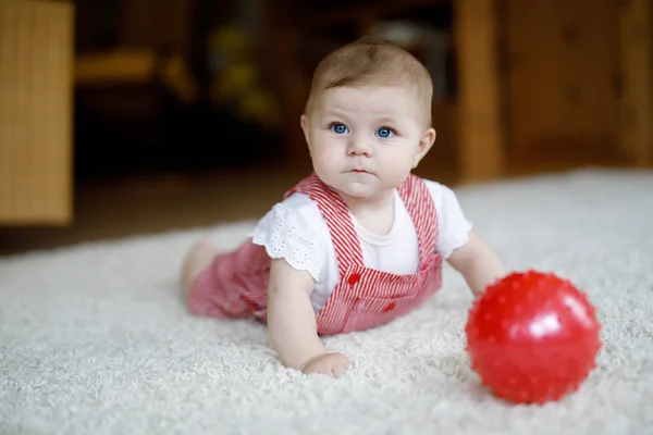 Mignon bébé fille jouer avec la boule de gomme rouge . — Photo