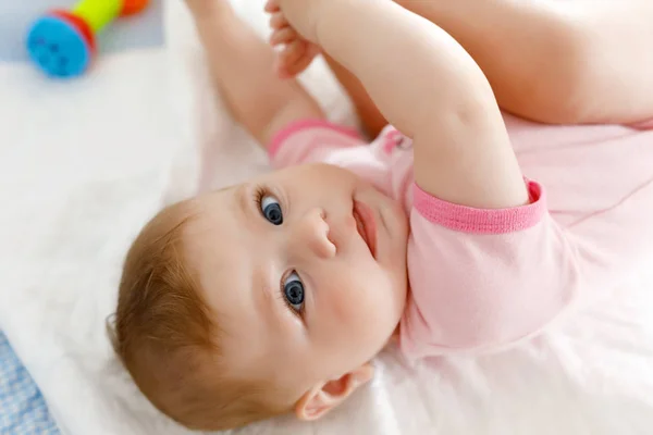 Niedliches Baby, das Füße in den Mund nimmt. entzückende kleine Mädchen lutschen Fuß. — Stockfoto