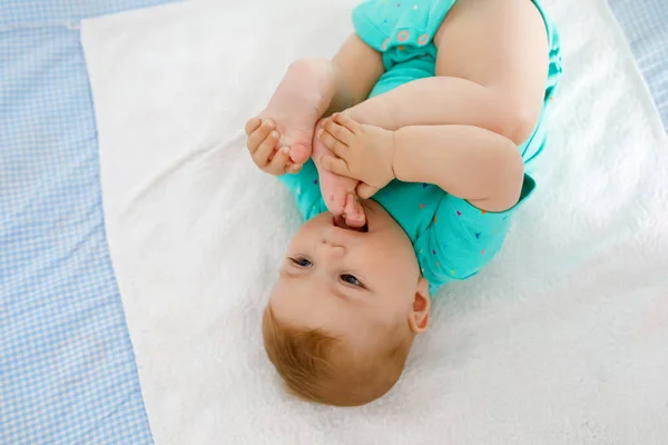 Cute baby biorąc stopy w ustach. Urocza dziewczynka baby ssanie stóp. — Zdjęcie stockowe