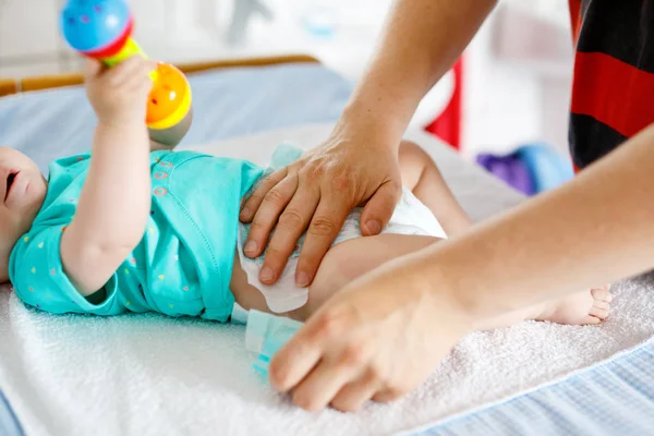 Primer plano del padre cambiando el pañal de su hija recién nacida . —  Fotos de Stock