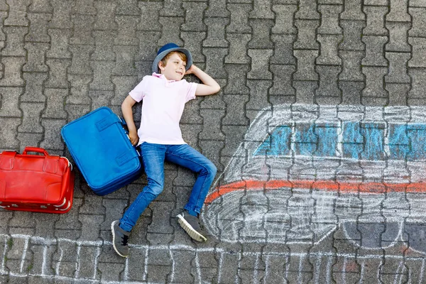 Bambino che si diverte con il disegno veloce immagine treno con gessetti colorati su asfalto — Foto Stock