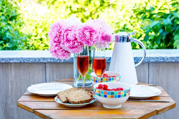 Breakfast table with bread, frest vegetables and berries, coffee and champagne served on balkony or hotel on summer morning — Stock Photo, Image