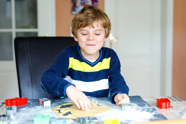 Carino bambino che cuoce biscotti di Natale pan di zenzero a casa. Adorabile bambino biondo che si diverte in cucina domestica. Tempo libero tradizionale con i bambini a Natale . — Foto Stock