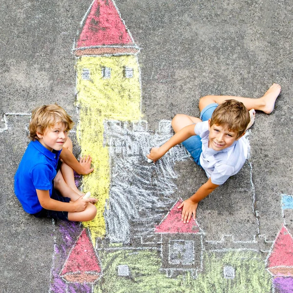 Två barn lite pojkar ritning knight slott med färgglada kritor på asfalt. Glada syskon och vänner att ha kul med att skapa krita bild och måleri. Kreativ fritid för barn i sommar. — Stockfoto