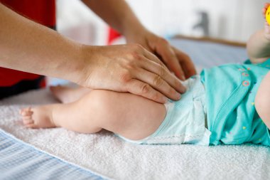 Yeni doğan bebek kızının bebek bezi değiştirme baba close-up. Küçük çocuk, kız banyo çıngırak oyuncaklar ile tablo değiştirme