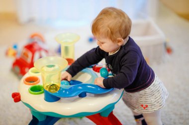 Ev veya kreş eğitim Sıralayıcı oyuncaklar ile oynarken sevimli sevimli güzel küçük bebek kız. Sağlıklı mutlu Toddler çocuk öğrenme renk ve formları sıralama