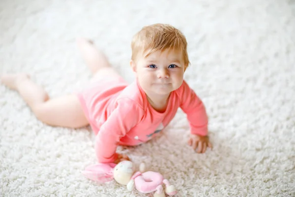 Niña linda aprendiendo a gatear. Niño sano arrastrándose en la habitación de los niños con juguetes de colores. Vista trasera de las piernas del bebé. Lindo niño descubriendo el hogar y aprendiendo diferentes habilidades — Foto de Stock