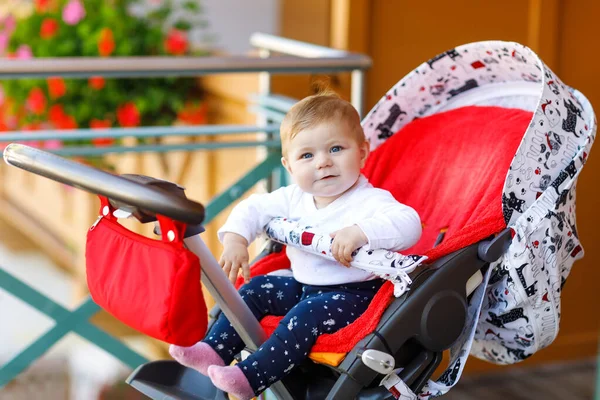 귀여운 작은 아름 다운 아기 소녀 유모차 또는 유모차에 앉아서 엄마를 기다리고. 파란 눈을 가진 행복 한 웃는 아이. — 스톡 사진