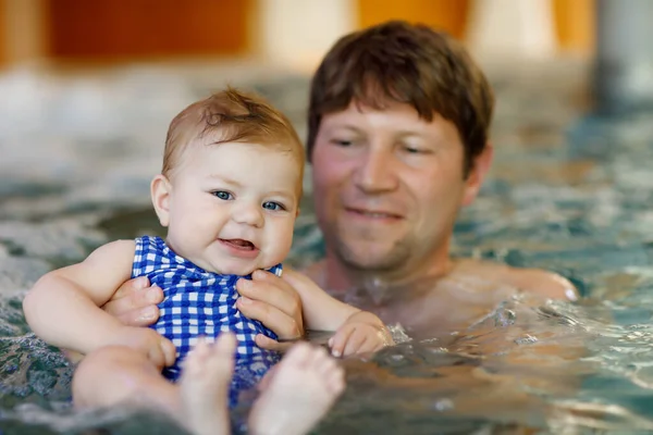 Glücklicher Vater mittleren Alters, der mit seiner süßen entzückenden kleinen Tochter im Whirlpool schwimmt. Lächelnder Vater und kleines Kind, Mädchen von 6 Monaten, die zusammen Spaß haben. Aktive Familienfreizeit im Kurhotel — Stockfoto