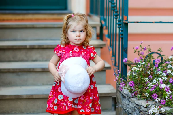 Retrato de bela menina pequena gorgeus adorável criança em rosa verão olhar roupas, vestido de moda, meias de joelho e chapéu. Criança bebê saudável feliz posando na frente da casa colorida. — Fotografia de Stock