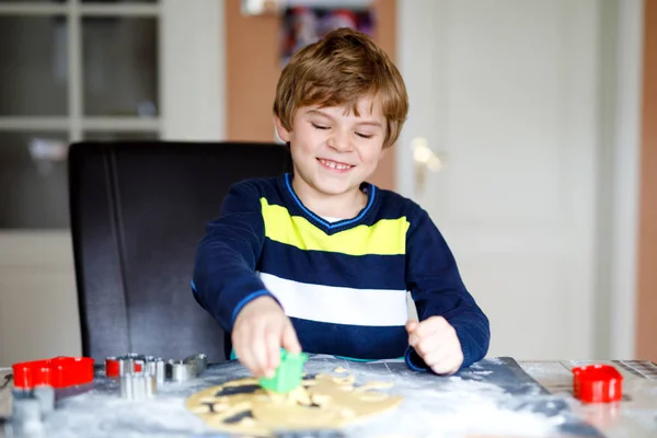 Bonito menino fazendo biscoitos de gengibre de Natal em casa. Criança loira adorável se divertindo na cozinha doméstica. Lazer tradicional com crianças no Xmas . — Fotografia de Stock