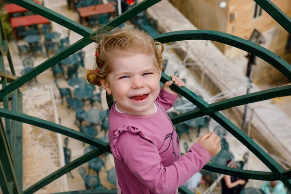 Porträtt av vackra små barn flicka på sommaren titta kläder som står på balkong i Venedig, Italien. — Stockfoto