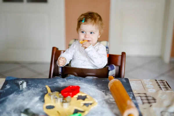 Carino bambina cuocere biscotti di Natale pan di zenzero a casa. Adorabile bionda felice bambino sano divertirsi in cucina domestica. Tempo libero tradizionale con bambini a Natale. Pasta degustazione bambino . — Foto Stock