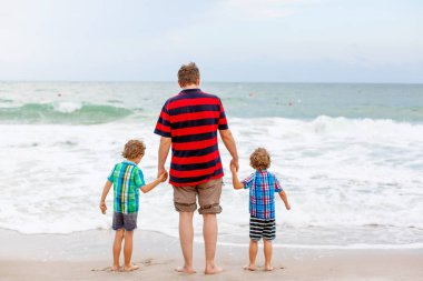 İki mutlu küçük çocuk okyanus sahilinde durup fırtınalı bir günde ufka bakıyorlar. Aile, baba ve tatlı oğullar tatil yapıyor, hayal kuruyor ve yazın tadını çıkarıyorlar.