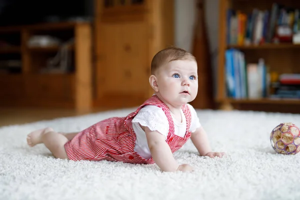 Cute baby playing with colorful rattle education toy. Lttle girl looking at the camera and crawling — Stock Photo, Image