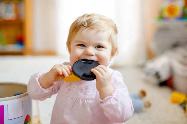 Precioso hermoso lindo hermoso bebé niña jugando con juguetes educativos en casa o guardería. Feliz niño sano que se divierte con coloridos juguetes diferentes. Niño aprendiendo diferentes habilidades . — Foto de Stock